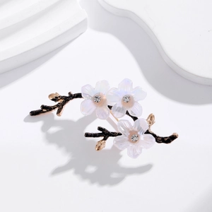 Elegant plum blossom brooch with white petals and crystals on white minimalist background