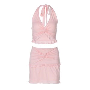 Detail of pink two-piece set featuring halter neck tie top and ruffled mini skirt textures