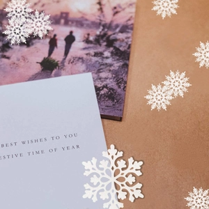 Close-up of white glitter snowflakes on brown kraft paper for Christmas tree decor