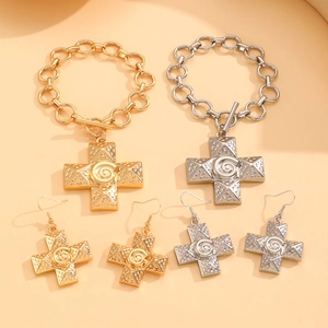 Detailed view of textured cross jewelry sets in gold and silver with toggle bracelets