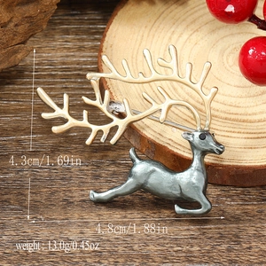 Macro shot of silver and gold reindeer brooch showing 4.3cm height and 4.8cm length details