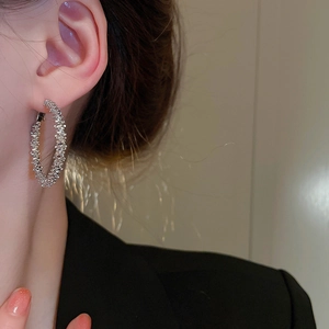 Textured silver geometric hoop earrings in minimalist style worn by a model