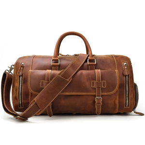 Detail view of brown vintage leather duffel bag with buckled pocket and bronze hardware