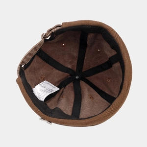Detailed view of the brown corduroy docker cap interior with a white washing label