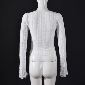 Detailed back view of white floral lace long sleeve top featuring intricate crochet texture
