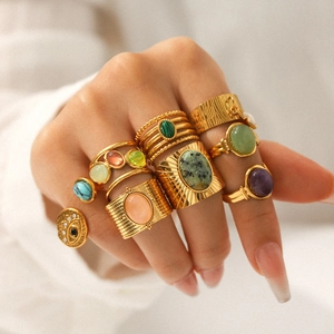 Vintage bohemian gold rings set with natural stones on fingers in soft light