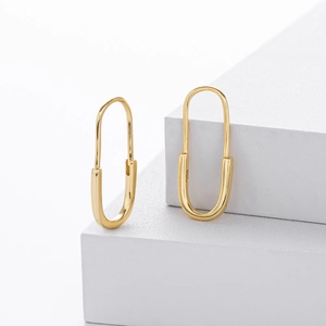 Minimalist gold S925 sterling silver paperclip hoop earrings displayed on white steps
