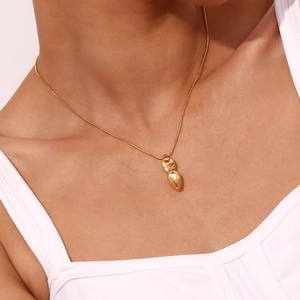 Gros plan d'un collier avec pendentif poignard en acier inoxydable plaqué or 18 carats