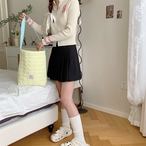 Detailed view of yellow heart quilted fabric and contrasting light blue shoulder strap