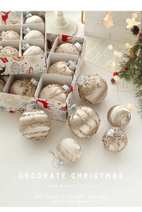 Detail of champagne satin Christmas ornaments with gold sequins and glitter in a gift box