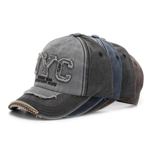 Detail of vintage washed cotton baseball caps showing NYC embroidery and worn brim textures
