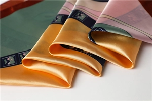 Close-up of the smooth silk texture and detailed botanical patterns on the satin scarf
