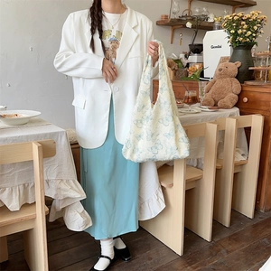Detail of cream-white knit tote bag featuring soft light blue butterfly patterns
