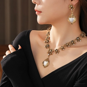 Gros plan d'une parure vintage avec perles et diamants portée par un mannequin féminin
