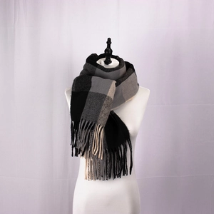 Detailed view of British style black gray beige plaid scarf with fringe on a mannequin