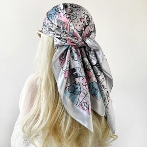 Detail of blonde hair styled with a colorful cat print satin silk square scarf