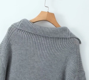 Detailed view of grey knit sweater showing oversized lapel and fine ribbed texture