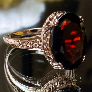 Vintage rose gold ring featuring a large oval red zircon with floral engraved band