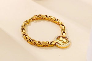 Detailed view of gold chain link with a sparkling zircon-encrusted family pendant charm