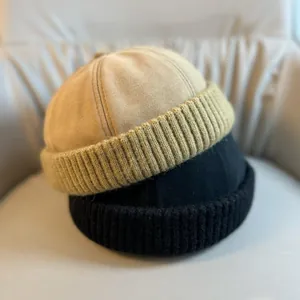 Detail view of khaki and black miki hats with knitted rib cuff and smooth crown texture