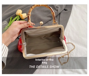 Macro view of floral embroidery bag with bamboo handle and interior zipper pocket