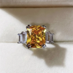 Macro view of luxury emerald-cut yellow zircon ring with silver setting in a box