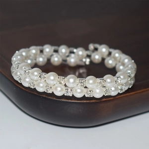 Detailed macro view of a double-layer bracelet with white pearls and sparkling rhinestones
