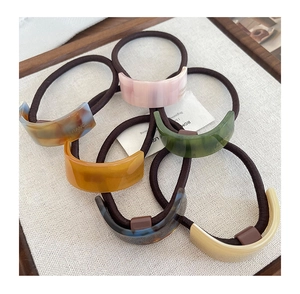 Detailed view of six vintage acetate ponytail holders with France Handmade lettering