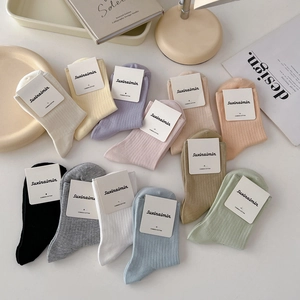 Colorful set of mid-calf combed cotton socks in 11 pastel shades laid flat on a clean surface