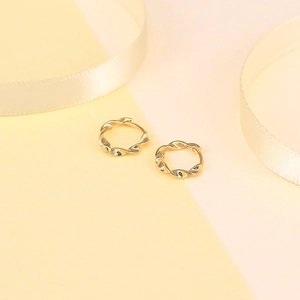 Detailed view of small S925 sterling silver gold twisted hoop earrings on silk ribbon