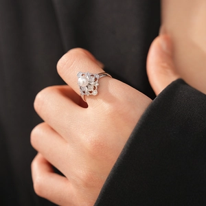 Detail of vintage hollow silver ring with white pearl and sparkling pavé accents