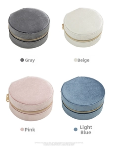 Round velvet jewelry boxes in gray, beige, pink, and blue with metal zipper closures