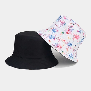 Détail de chapeaux bobs réversibles à fleurs et noir uni en toile de coton