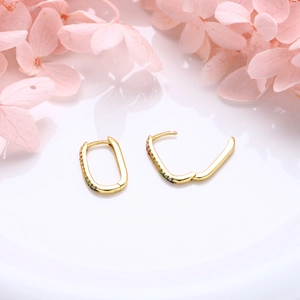 Detail view of gold U-shaped silver earrings with colorful zircon rainbow setting