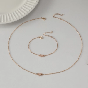 Elegant gold chain necklace and bracelet set with delicate pink heart pendants