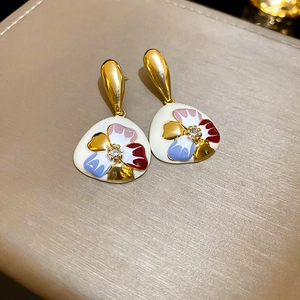 Detail von Vintage-Emaillblumenohrringen mit funkelndem Diamantzentrum und Goldhaken