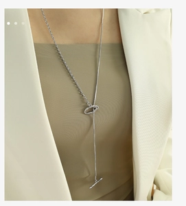 Detail of silver irregular OT buckle Y-necklace with lava pendant on a chic blazer