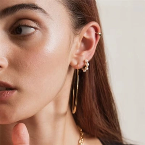 Close-up of model wearing S925 silver geometric pearl hoop earrings and gold necklace