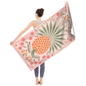 Detailed shot of double-sided microfiber beach towel with vibrant pineapple print and floral edge