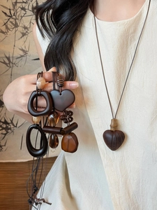 Detail showing vintage wood resin oval and heart pendants on braided cords