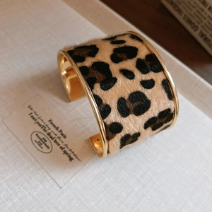 Détail d'un bracelet ouvert plaqué or avec incrustation en fourrure motif léopard chic