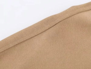 Vue macro de l'ourlet à double couture sur le pantalon tricoté kaki de qualité