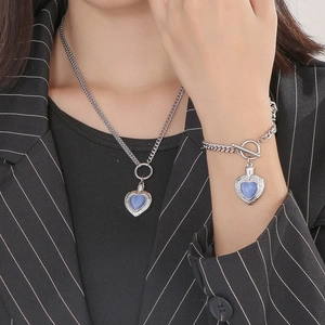Détail de l'ensemble collier et bracelet cœur en opale argentée avec fermoir à bascule OT