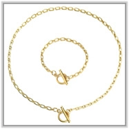 Detailed macro view of gold-tone chain necklace and bracelet set with OT toggle clasps
