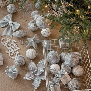 Silver Christmas tree ornament set with sparkling balls, bows, and star on wood