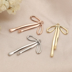 18K gold plated bow-shaped jewelry pendants in three metallic colors on satin fabric