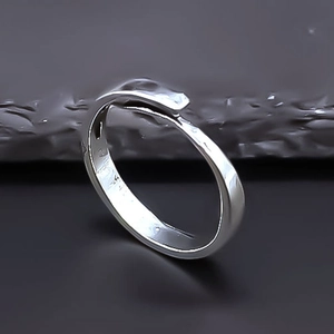 Detailed side view of silver adjustable heart ring on dark grey stone surface