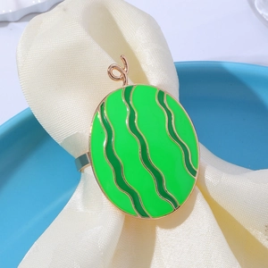 Macro view of green enamel watermelon napkin ring with gold edges on beige fabric