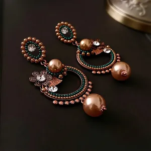 Boucles d'oreilles baroques vintage avec perles et cristaux floraux sur fond sombre