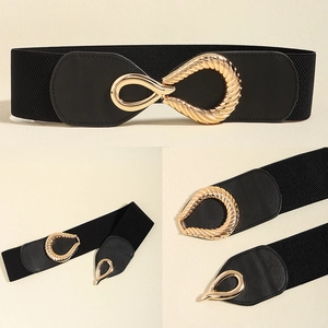 Detail of interlocking gold teardrop buckle on a black elastic waist belt for dresses